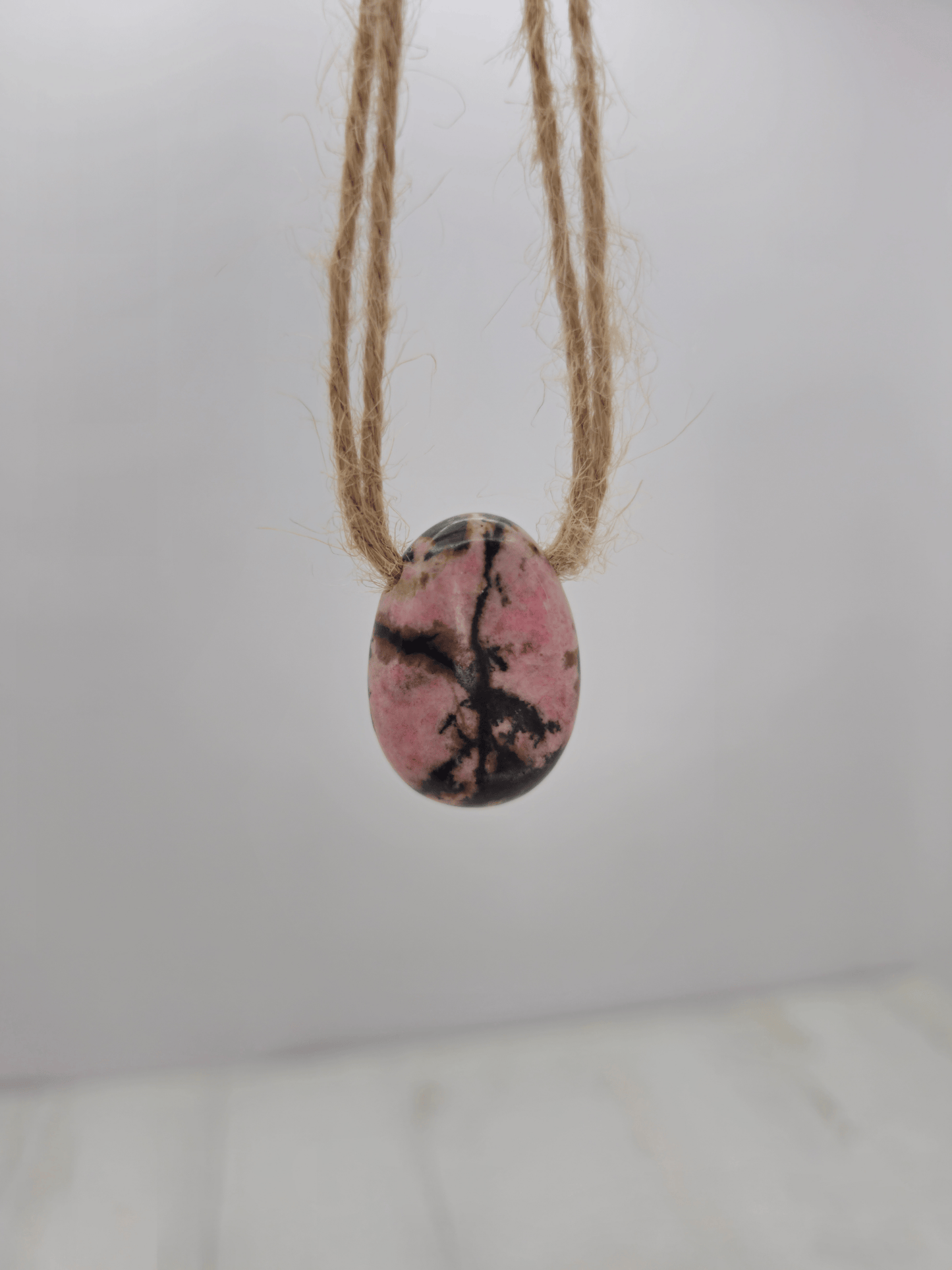 Colgante de rodonita rosa, rojo y negro, 20–30 mm, perforado lateral, ideal para sanación emocional y conexión con el corazón.