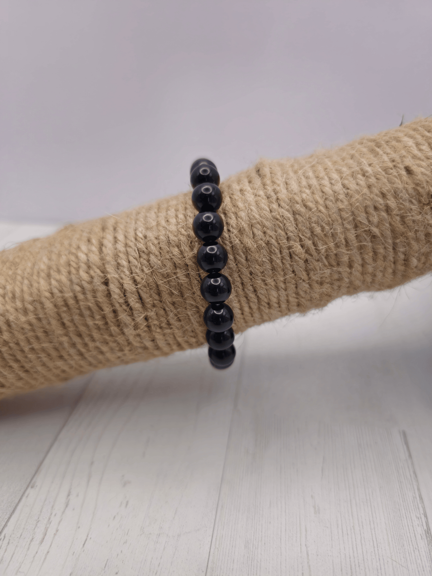 Pulsera de ónix con bolas de 8 mm, montada en hilo elástico, ideal para protección energética y fortaleza emocional.