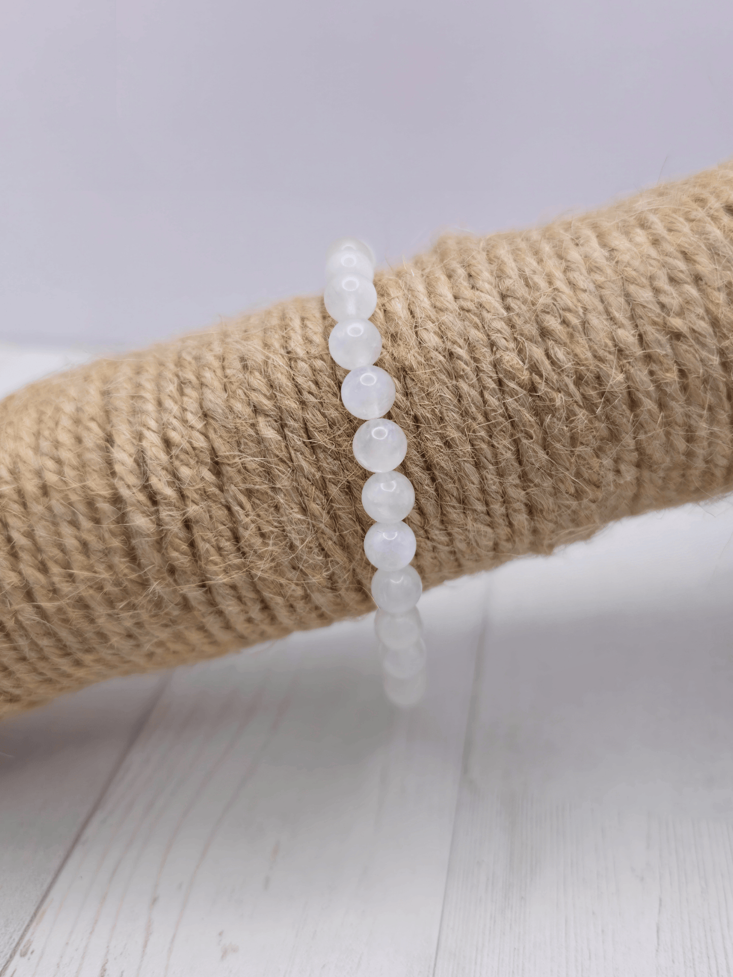 Pulsera de piedra luna con bolas de 6 mm, montada en hilo elástico, ideal para potenciar la intuición y el equilibrio emocional.
