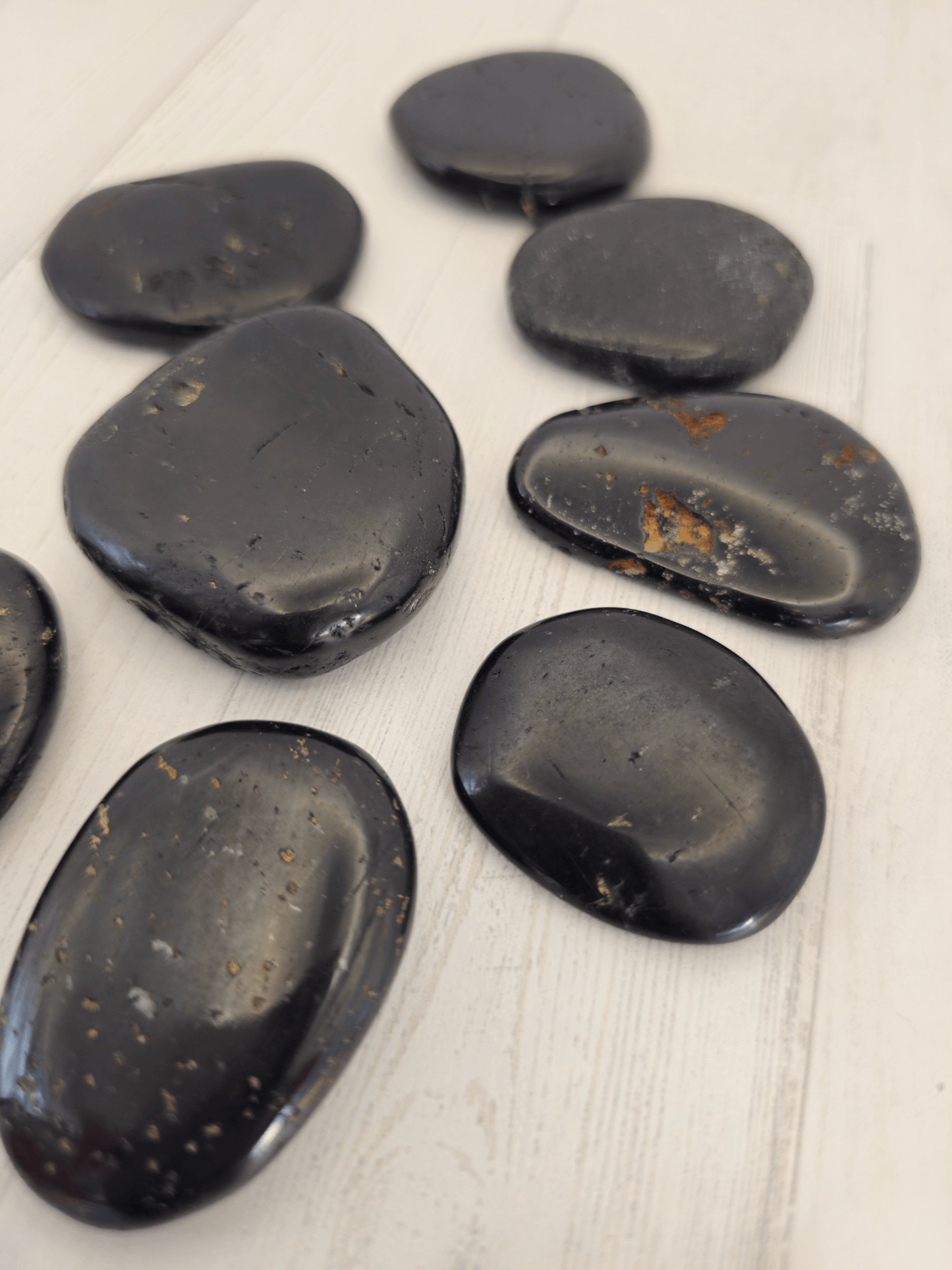 Rodado plano de turmalina negra de 37–53 mm, pieza única ideal para equilibrio energético y acompañamiento protector.