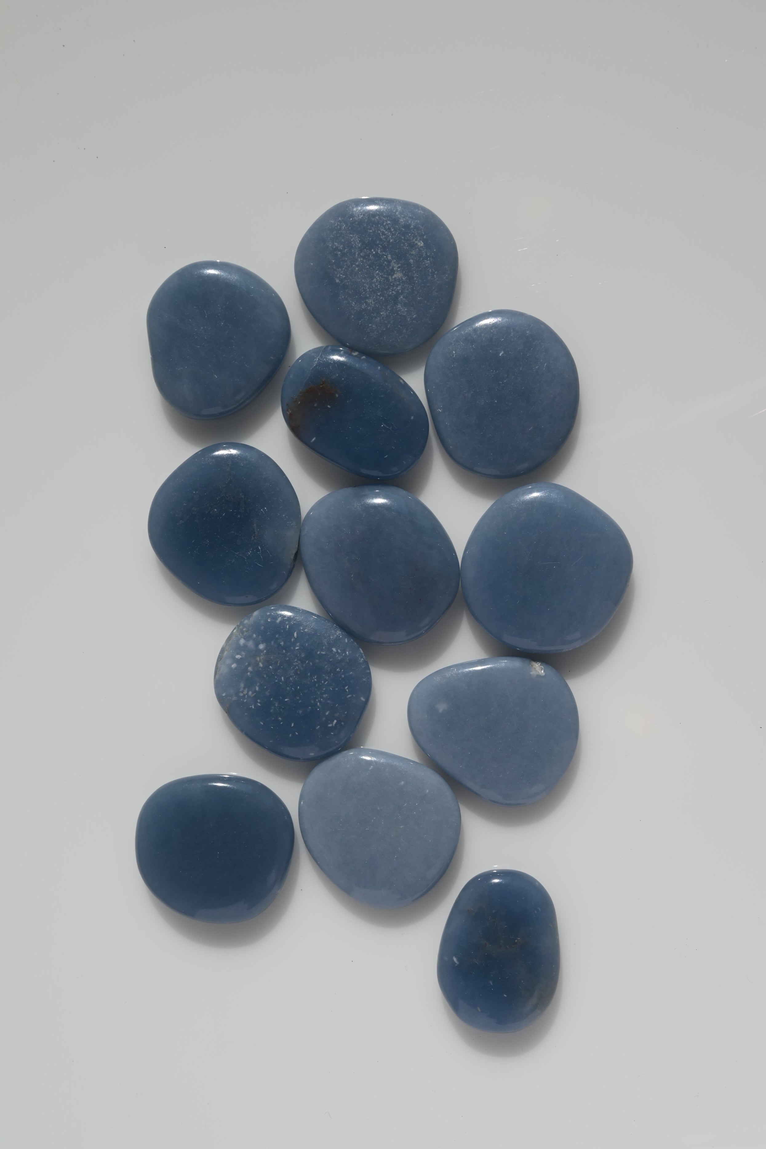 Rodado plano de Angelita de forma circular, color azul celeste, 3,5 cm. Mineral pulido ideal para meditación y comunicación espiritual.