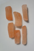 Barra de selenita naranja natural sin pulir, 5 a 7 cm. Mineral cálido ideal para limpieza energética y equilibrio emocional.