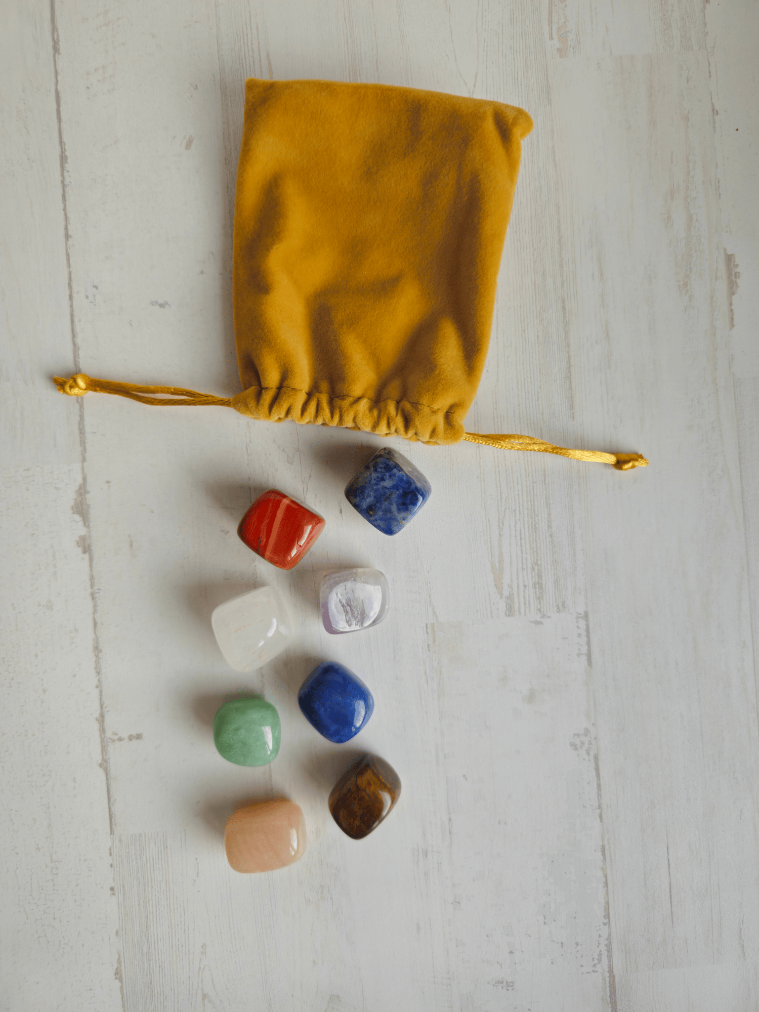 Bolsa con 8 minerales pulidos para equilibrar los 7 chakras: amatista, aventurinas, cristal de roca, jaspe rojo, sodalita, ojo de tigre.