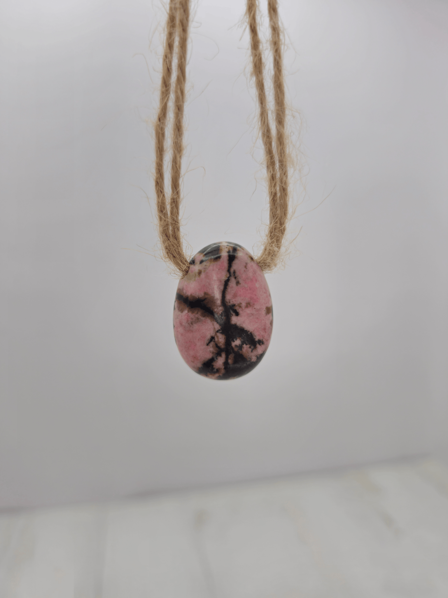 Colgante de rodonita rosa, rojo y negro, 20–30 mm, perforado lateral, ideal para sanación emocional y conexión con el corazón.