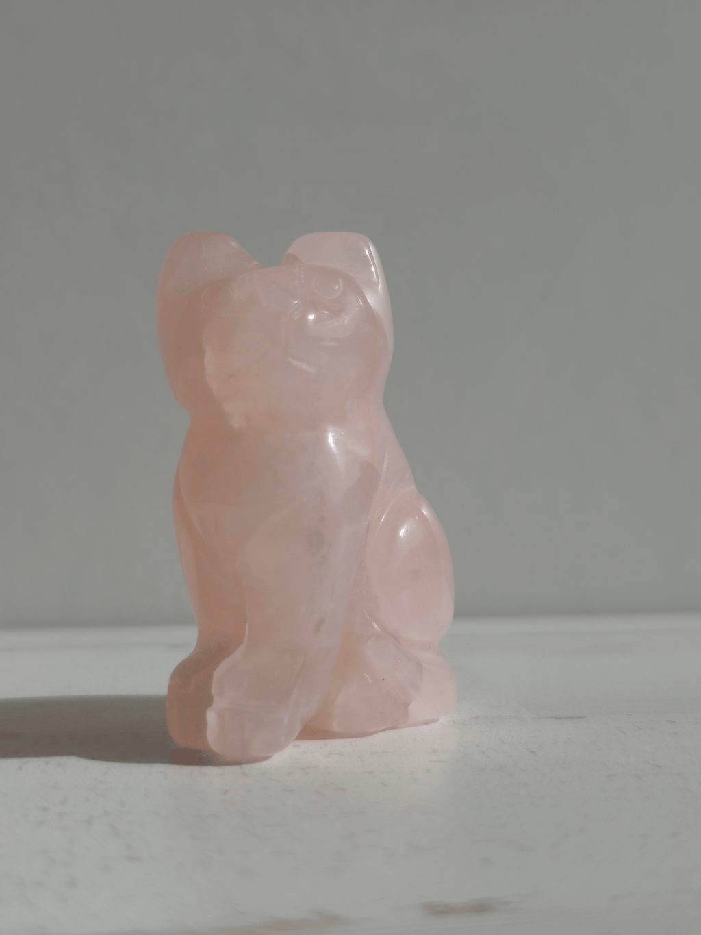 Figura tallada de gato en cuarzo rosa, 50 × 30 × 20 mm, símbolo de amor, sensibilidad y energía tierna.