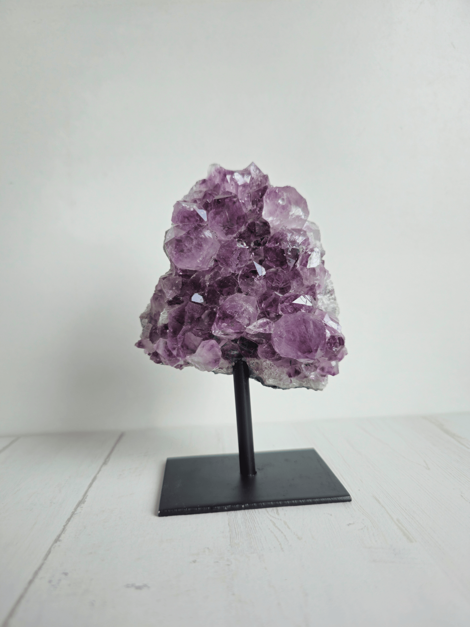 Peana pequeña de amatista natural sobre base metálica, ideal para elevar energía, purificar ambientes y potenciar intuición