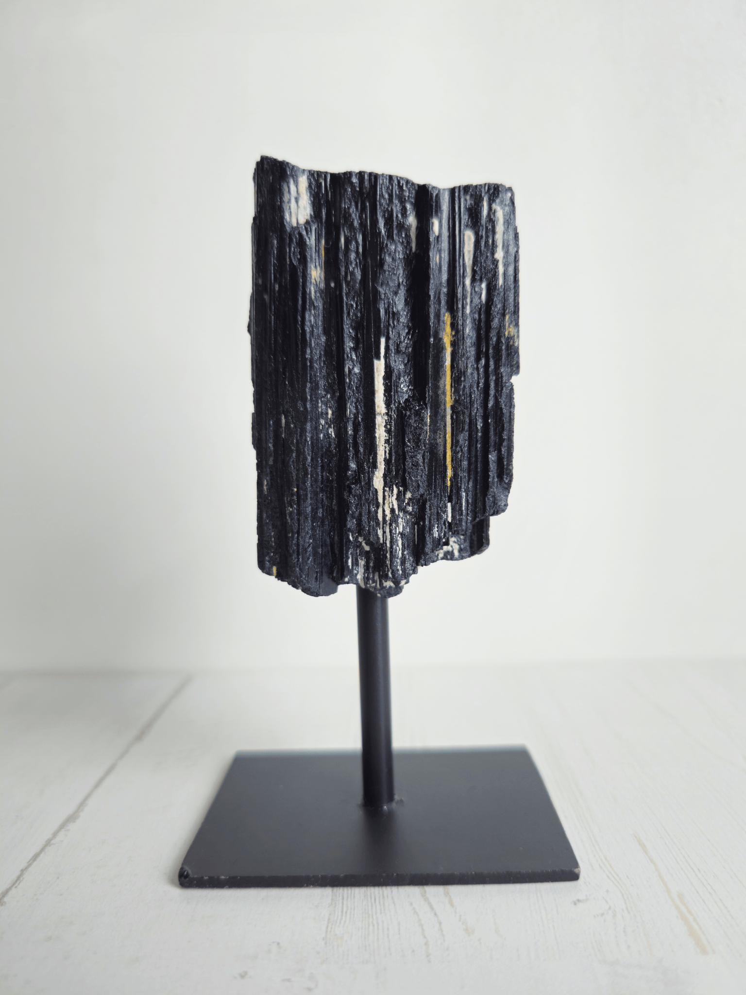 Turmalina negra en bruto con forma tipo catedral sobre base, piedra de protección energética, estabilidad emocional y enraizamiento interior