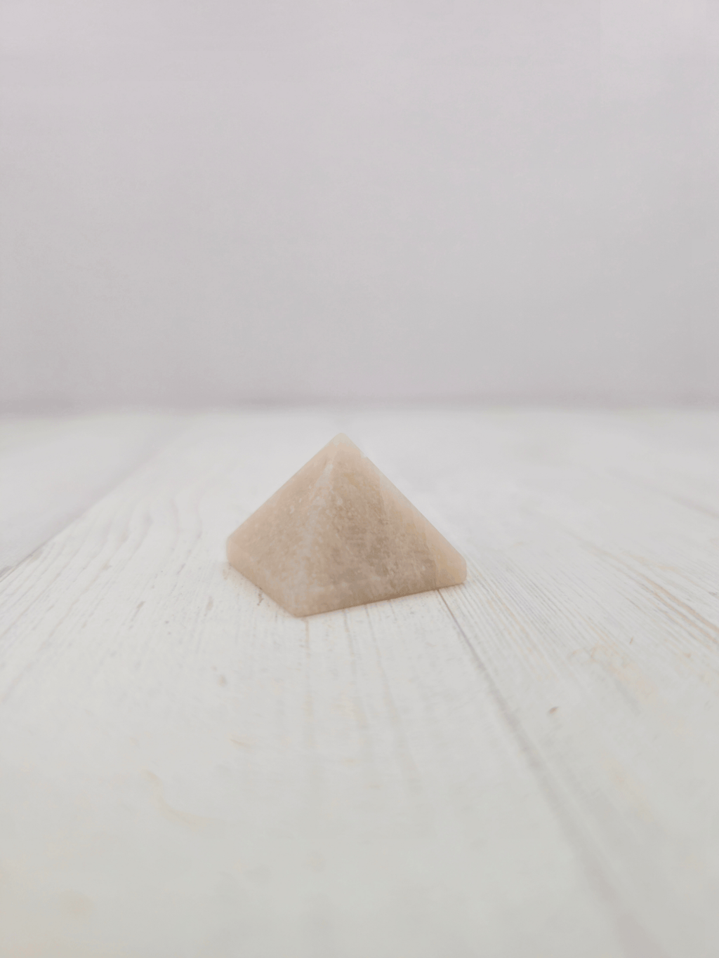 Pirámide de piedra luna beige de 25 mm, tonos blanco y beige con reflejos, ideal para intuición y equilibrio emocional.