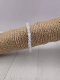 Pulsera de selenita con cuentas de 6 mm en tonos blancos y reflejos perlados, montada en hilo elástico, ideal para claridad mental y elevación energética.