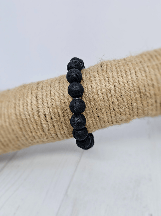 Pulsera de lava con bolas de 10 mm, montada en hilo elástico, ideal para energía vital, enraizamiento y protección energética.