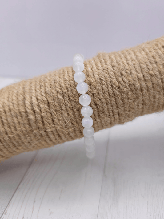 Pulsera de piedra luna con bolas de 6 mm, montada en hilo elástico, ideal para potenciar la intuición y el equilibrio emocional.