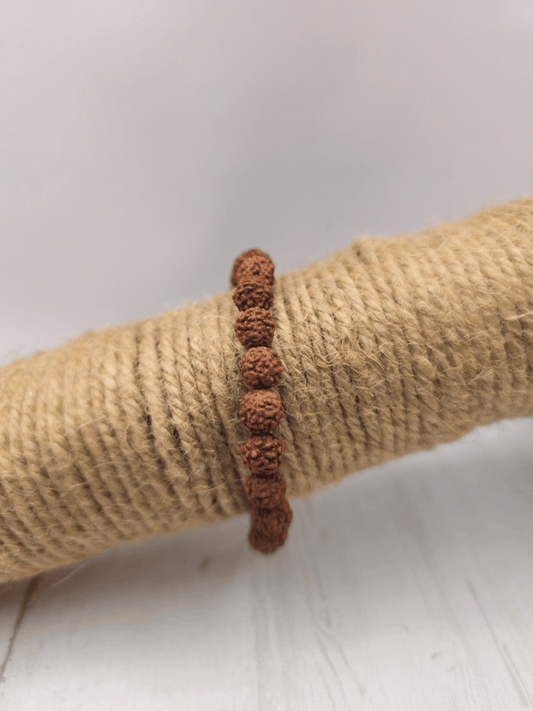 Pulsera de semillas de Rudraksha natural con cuentas de 6 mm, montada en hilo elástico, ideal para meditación, protección y equilibrio espiritual.