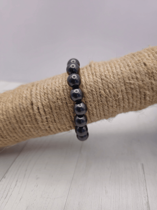 Pulsera de shungit con bolas de 10 mm, montada en hilo elástico, ideal para protección energética y absorción de radiación electromagnética.
