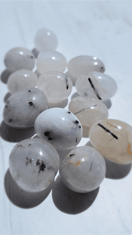 Rodado de cuarzo turmalinado (17–33 mm) en tonos negro y transparente, ideal para equilibrio emocional y salud vibratoria.