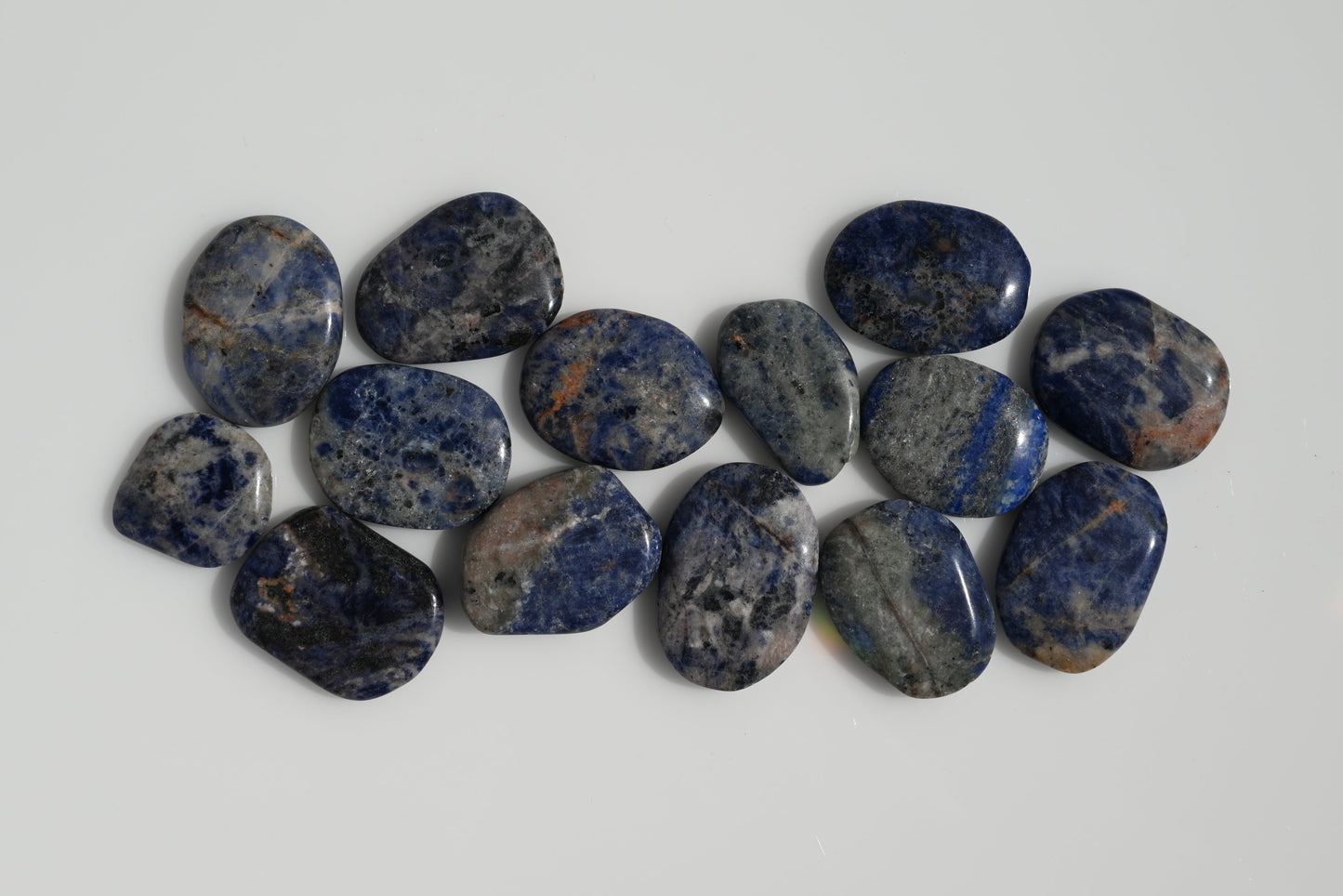 Rodado plano de sodalita azul con vetas blancas 30–50 mm