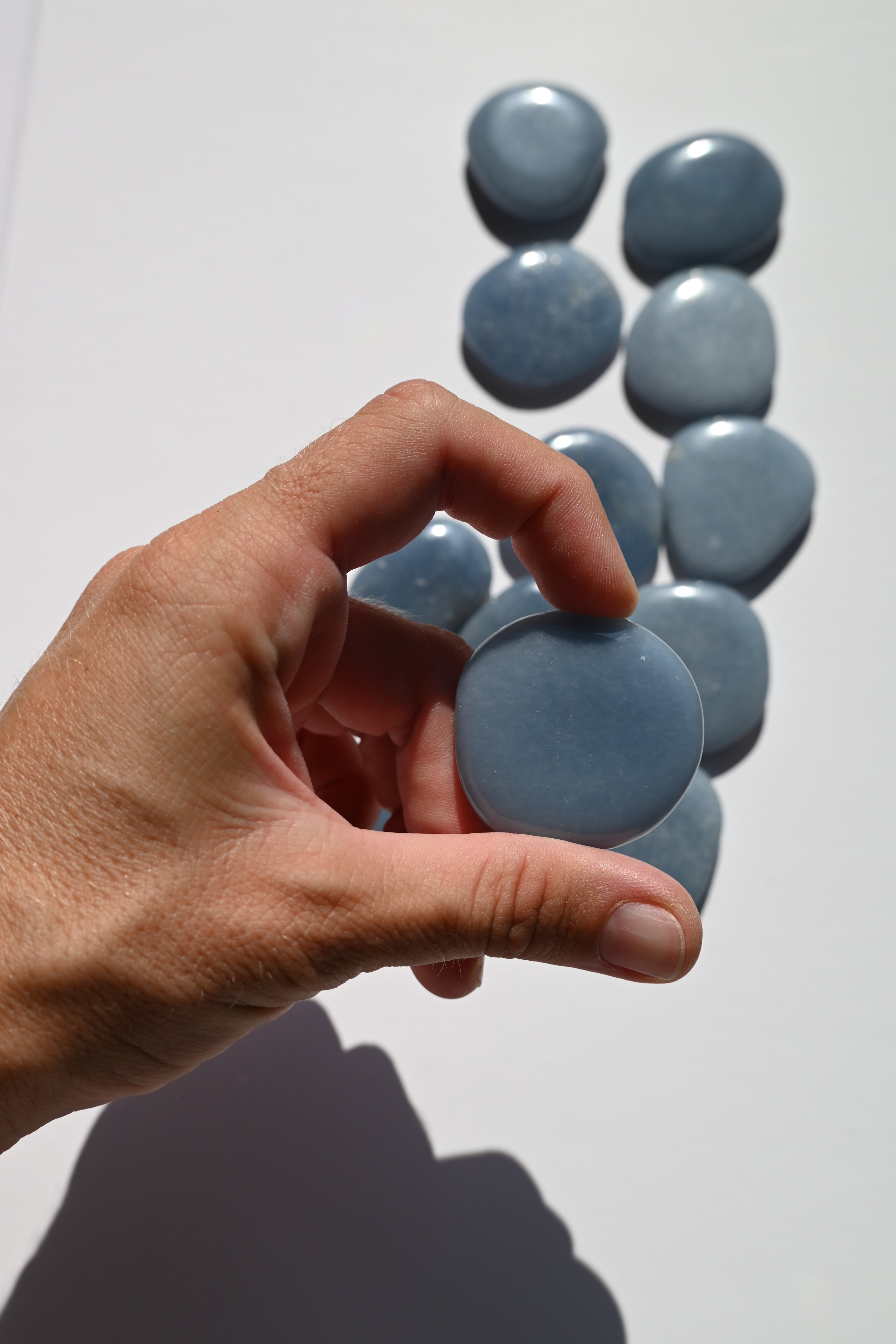 Rodado plano de Angelita de forma circular, color azul celeste, 3,5 cm. Mineral pulido ideal para meditación y comunicación espiritual.