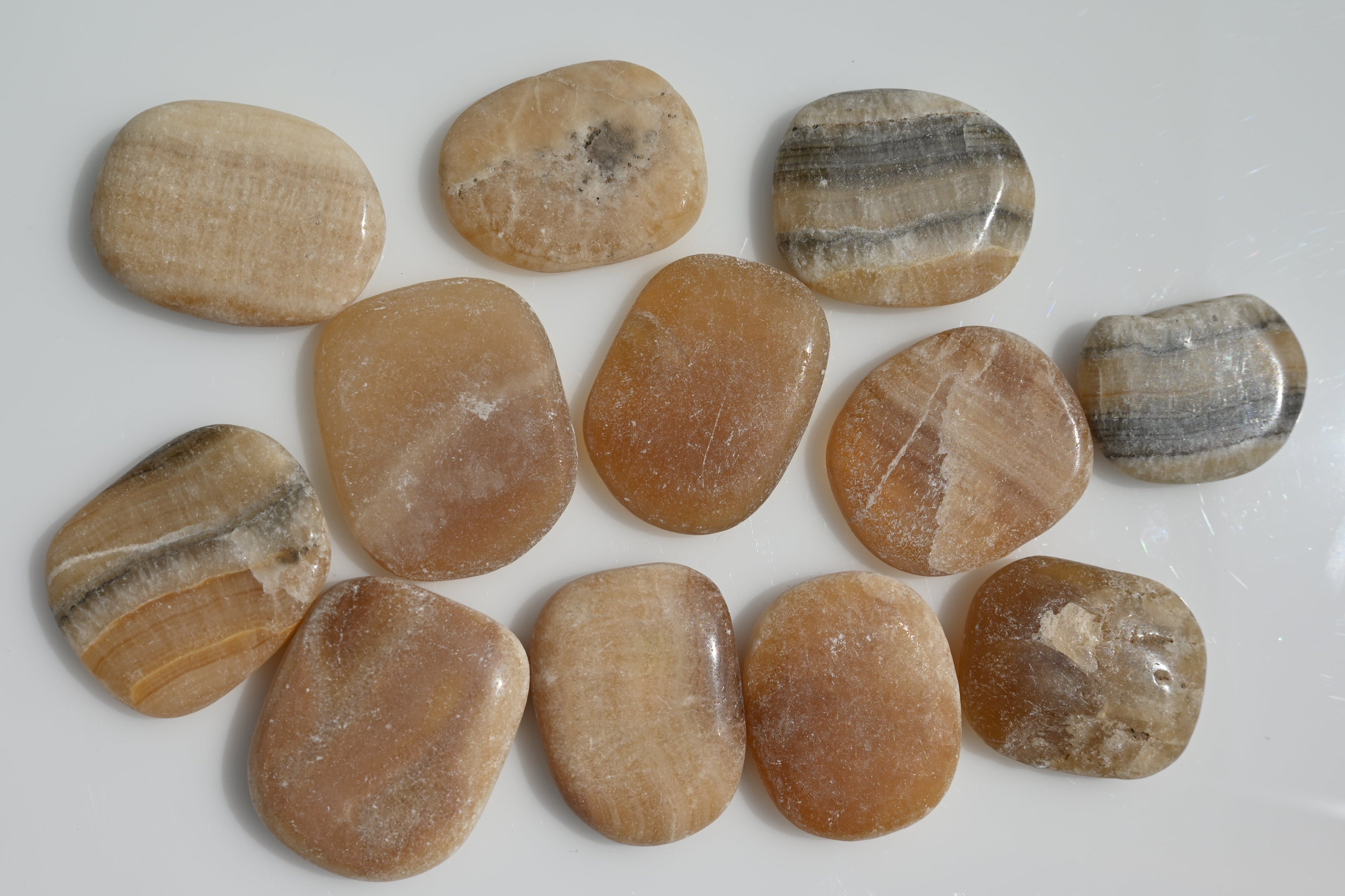 Rodado plano de aragonito 30–50 mm con vetas naturales