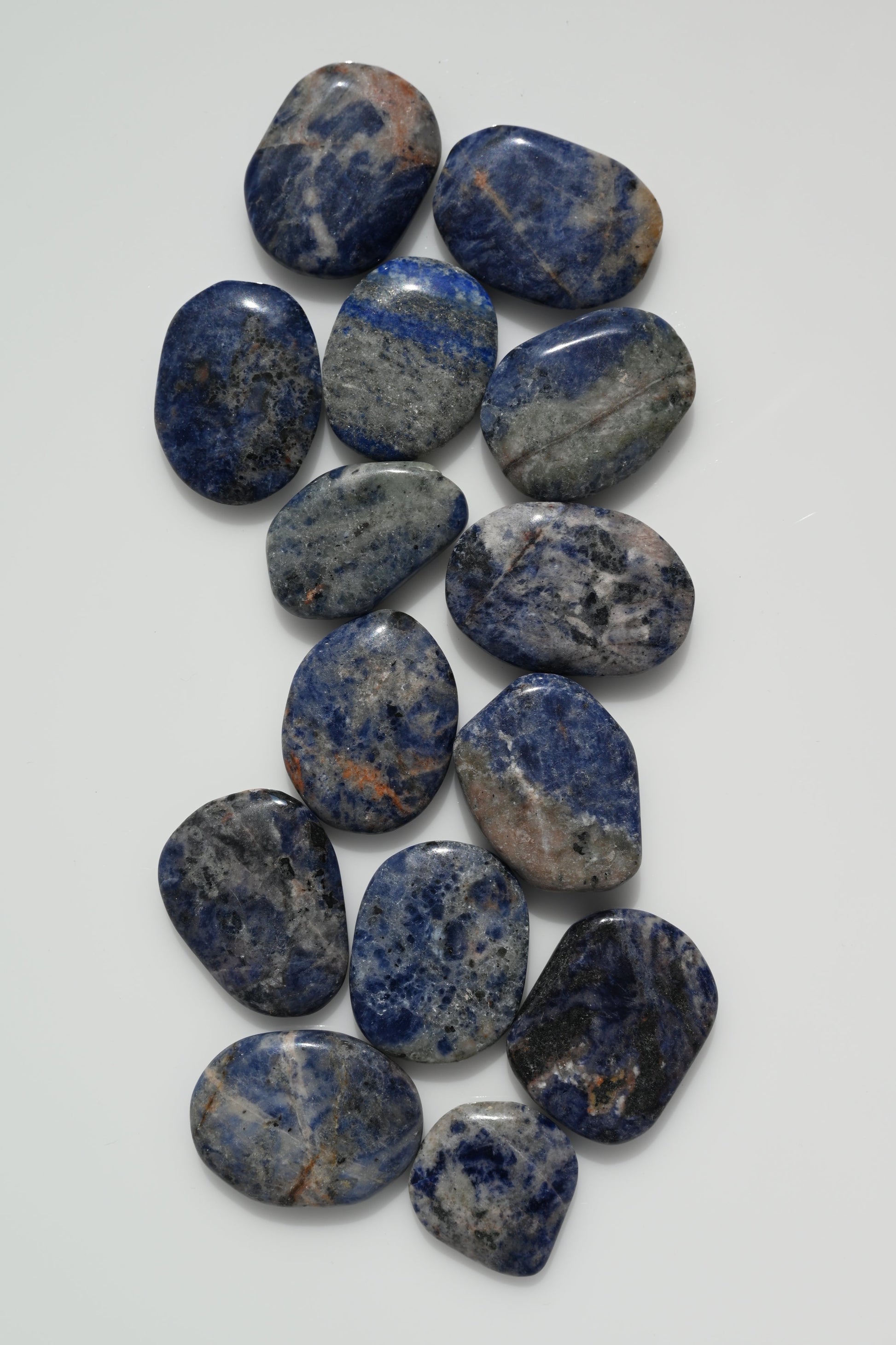 Rodado plano de sodalita azul con vetas blancas 30–50 mm
