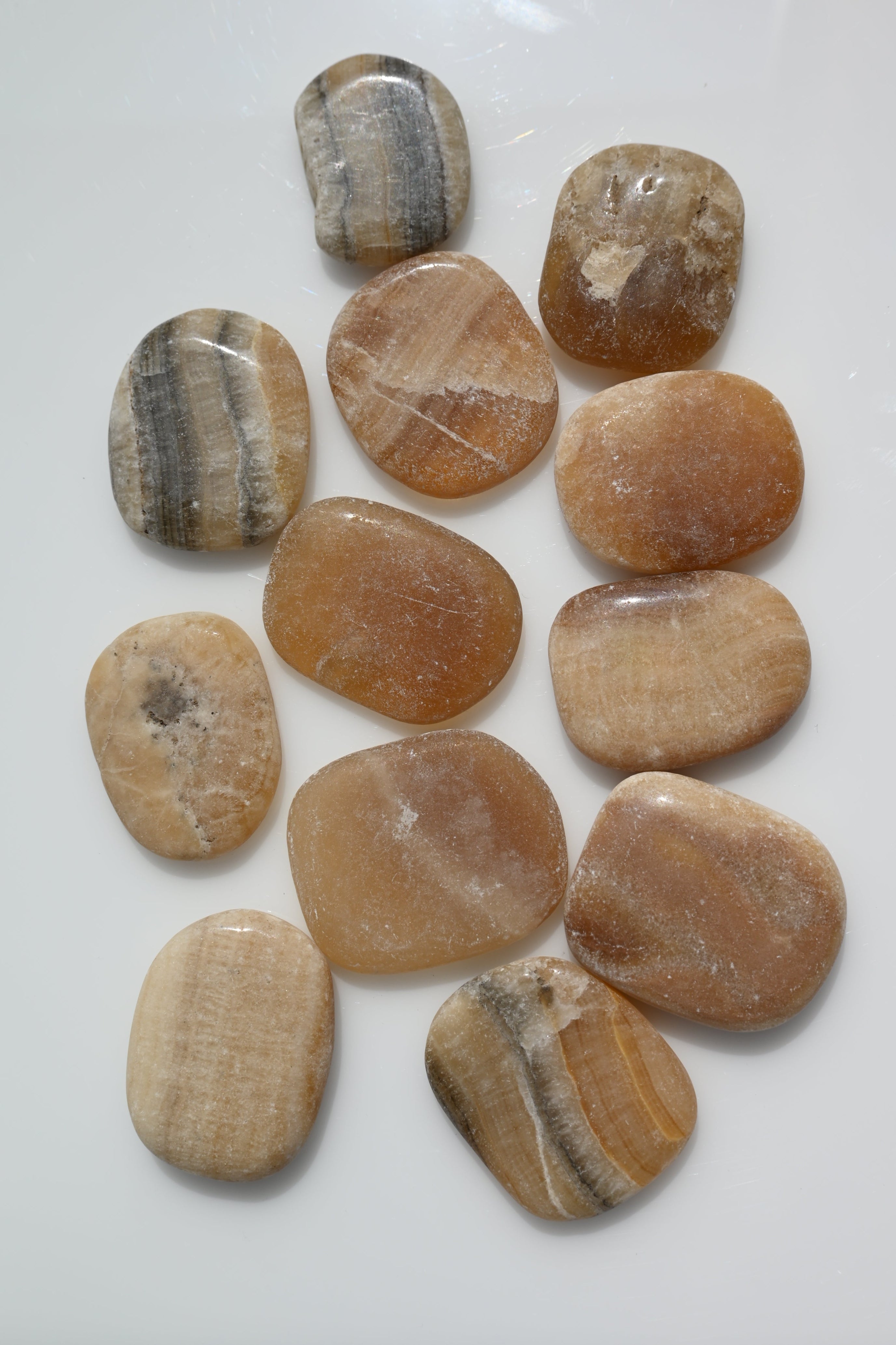 Rodado plano de aragonito 30–50 mm con vetas naturales