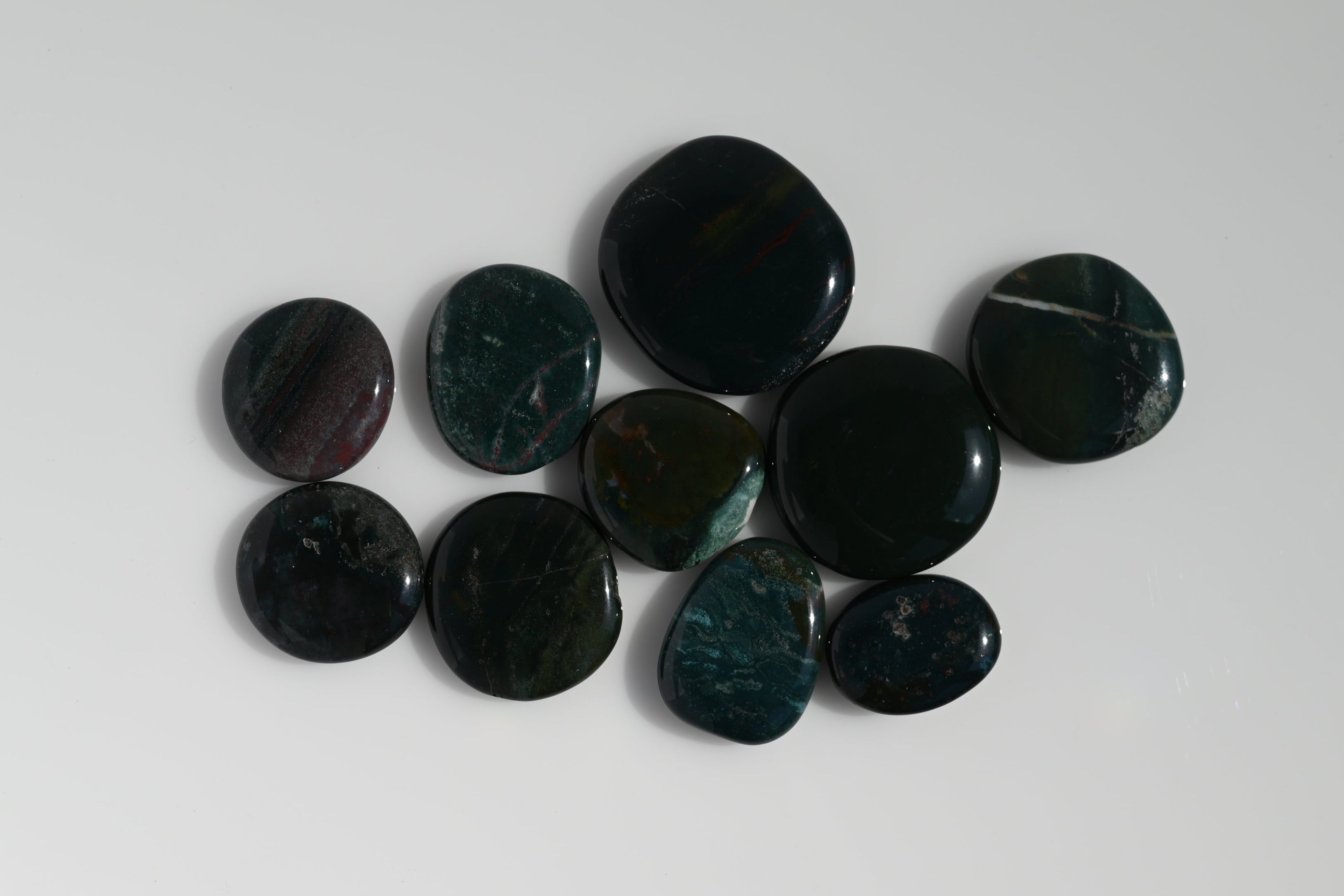 Rodado plano de heliotropo verde oscuro con inclusiones rojas 30–45 mm