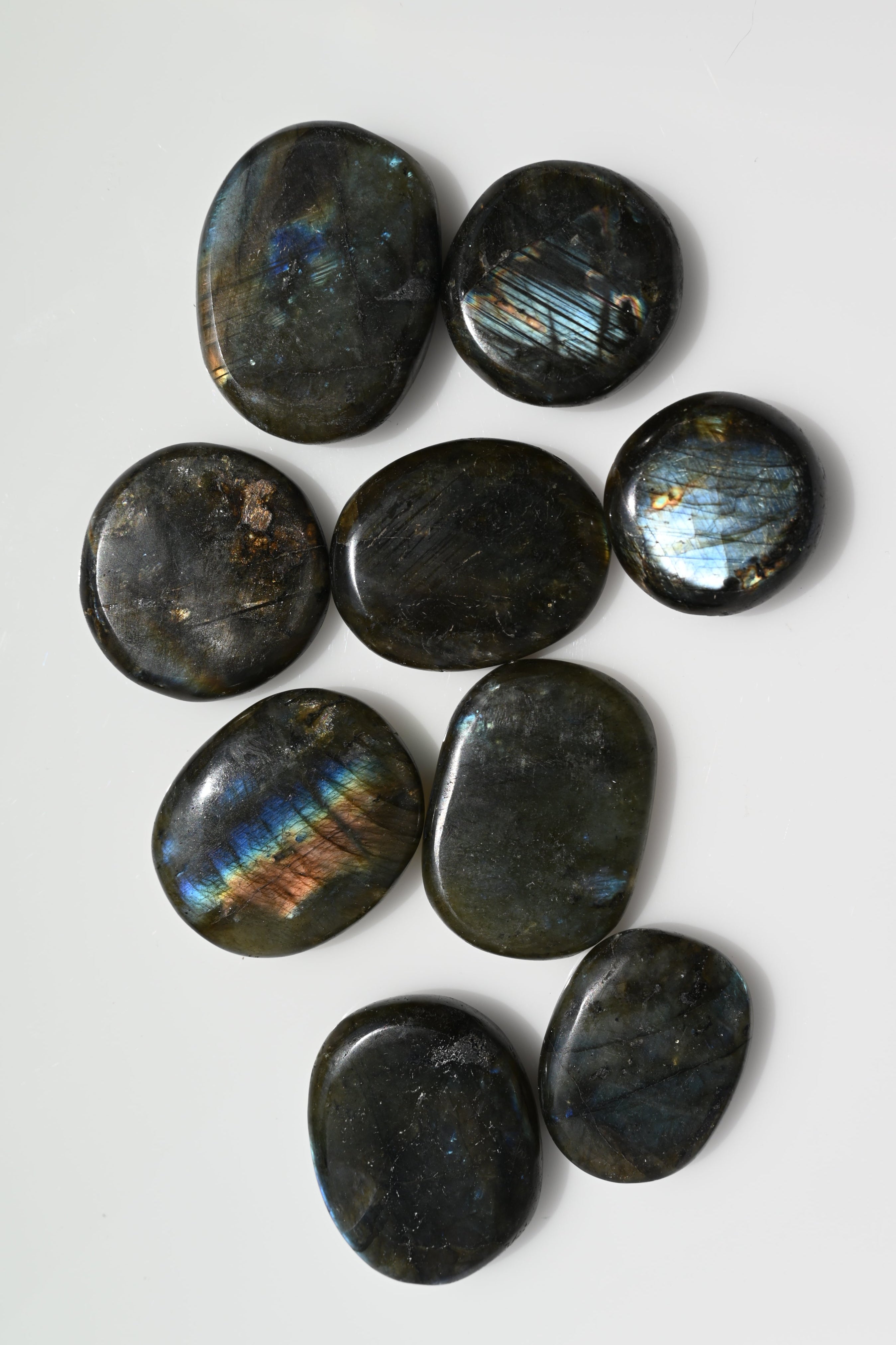 Rodado plano (disco) de labradorita 25–50 mm con iridiscencia azul y anaranjada