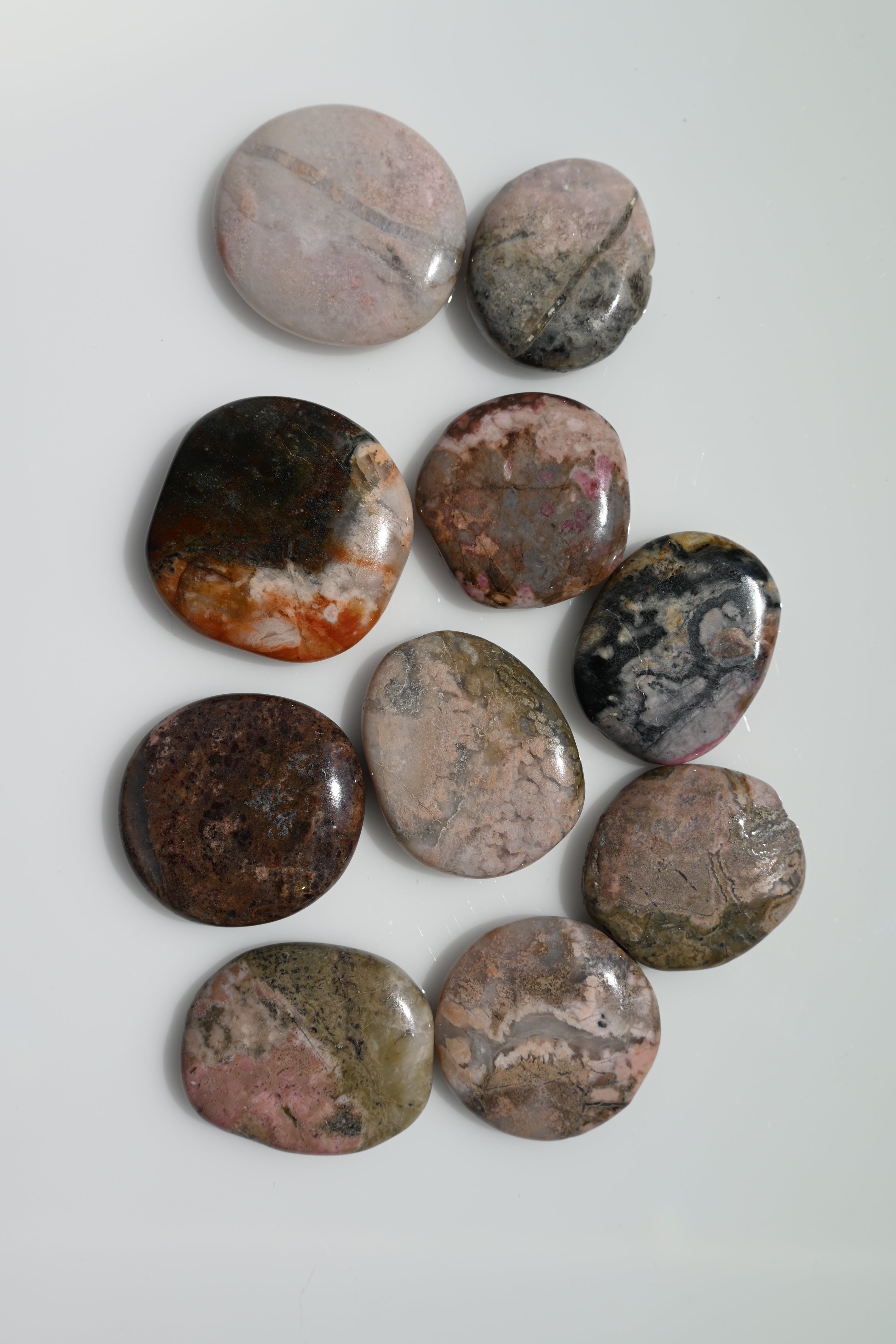 Rodado plano de rodonita rosa con vetas negras 35–40 mm