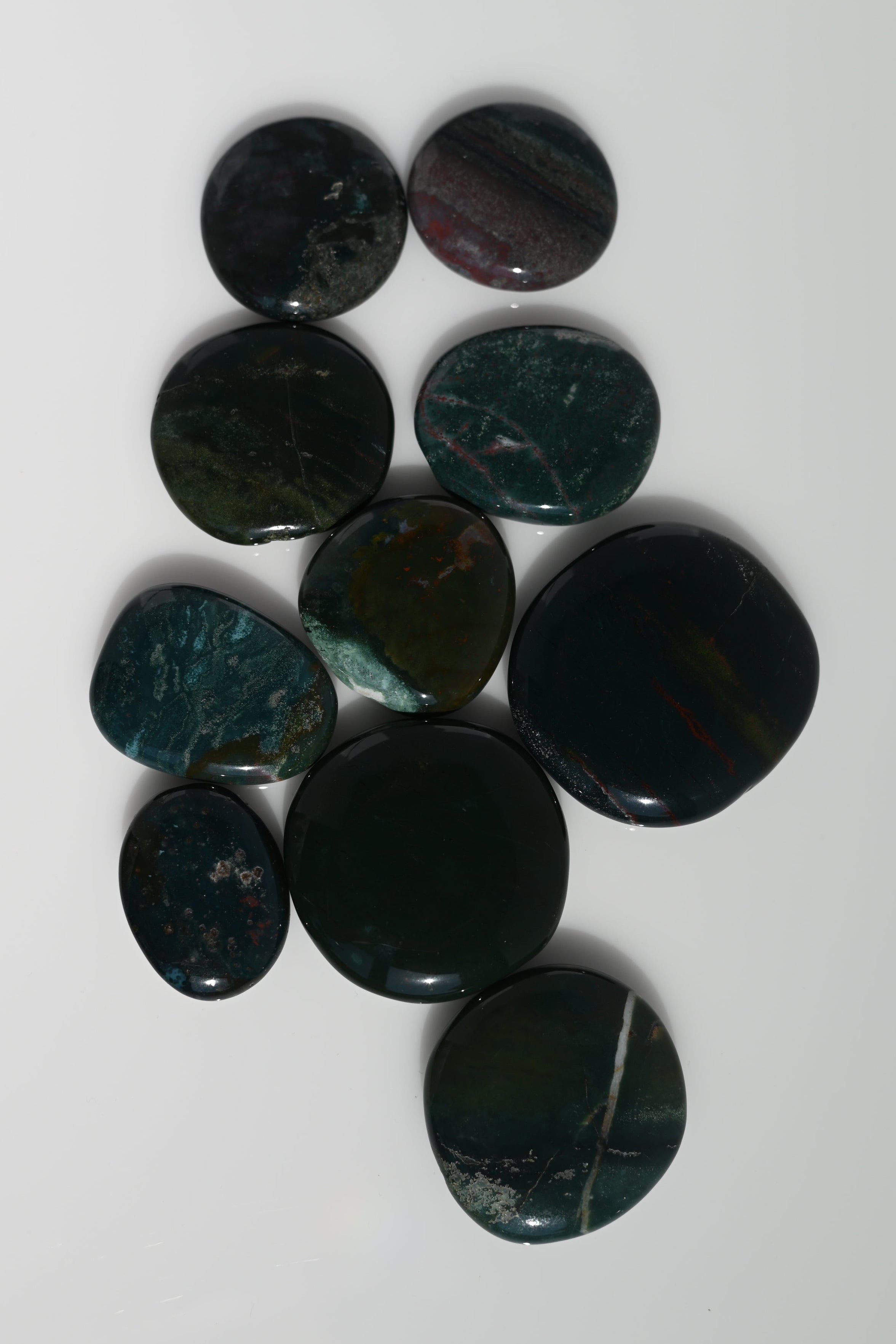 Rodado plano de heliotropo verde oscuro con inclusiones rojas 30–45 mm