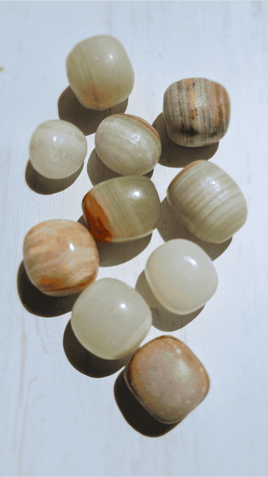 Rodado de aragonito 18–32 mm en tonos blanco, verde, marrón y amarillo; ideal para estabilidad emocional y enraizamiento.