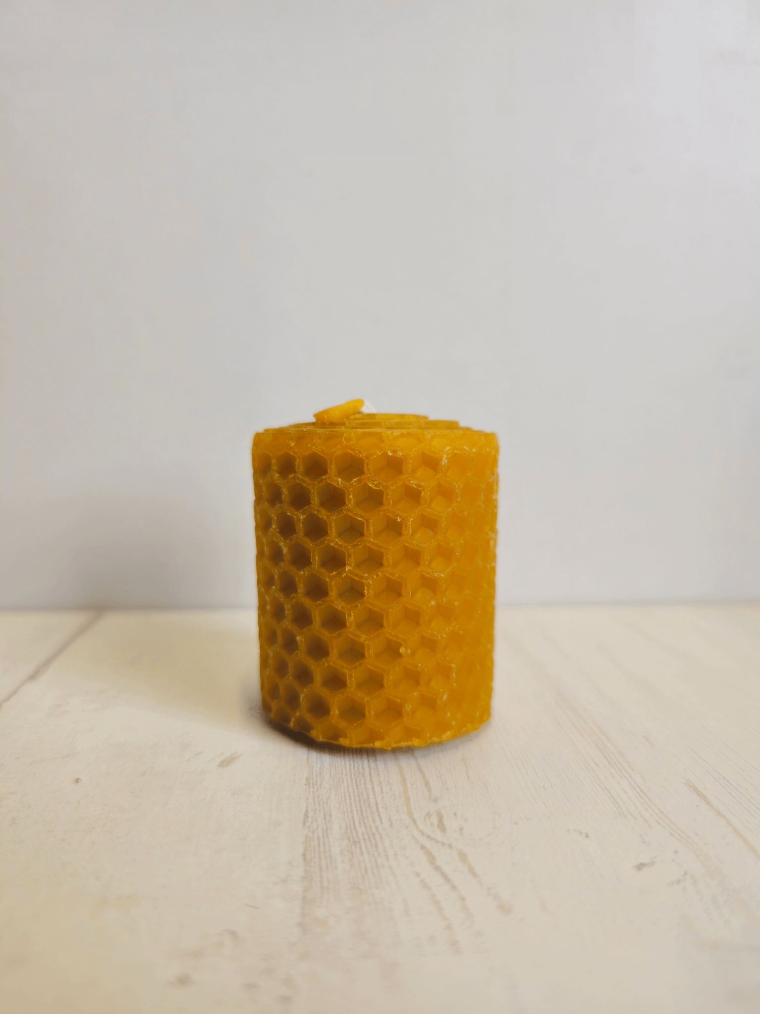 Vela artesanal de cera de abeja de 5 × 5 cm, ideal para iluminación suave o como complemento para sahumerios y rituales de bienestar.